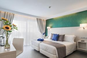 甘迪亚海滩埃斯金索滨海山庄公寓式酒店的配有一张床和花瓶的酒店客房