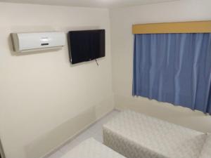 伊塔佩瓦Patriarca Hotel的小房间设有电视和窗户