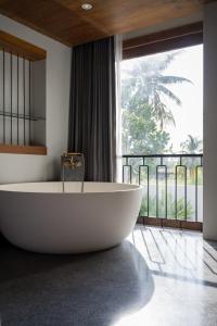 蔻立Hotel Gahn - SHA Plus的带浴缸的浴室和大窗户
