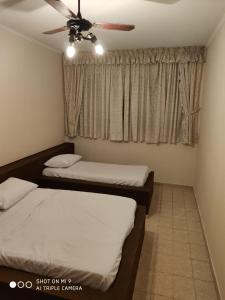 大普拉亚Casa Gomes的一间卧室配有两张床和吊扇