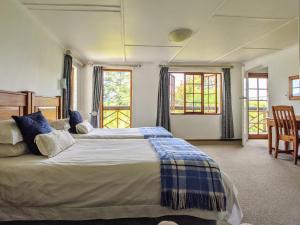 富里斯堡Wyndford Holiday Farm的一间卧室设有一张大床和两个窗户。