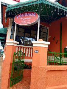 阿蒂巴亚Pousada Sayonara的大楼前有标志的餐厅