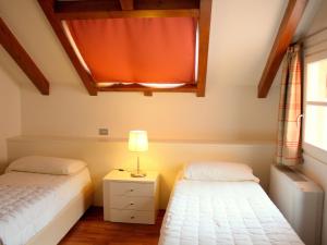 梅纳Brand new and elegant residence on Lake Maggiore的一间卧室配有两张床和床头灯。