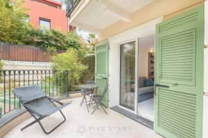 费拉角圣让Villa Artemys - Five Stars Holiday House的一个带绿门和桌椅的庭院