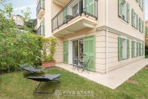 费拉角圣让Villa Artemys - Five Stars Holiday House的院子里带绿门和椅子的房子
