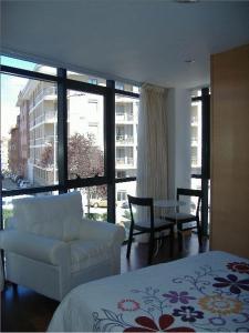 索里亚林孔德加拉酒店的一间卧室配有一张床、一把椅子和一个大窗户