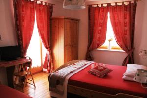 MendolaGarni Biancaneve Ruffrè-Mendola的一间卧室设有红色的床和窗户。