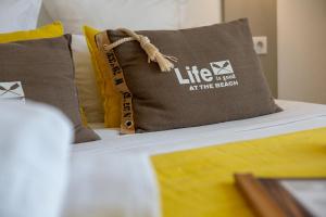 多吕多勒龙乐维特宝依斯酒店的一张带枕头的床,上面写着海滩上的生活