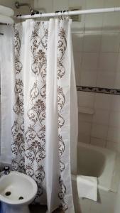 科尔多瓦Luminoso Depto con terraza propia y en la mejor ubicación的浴室设有白色的淋浴帘和水槽