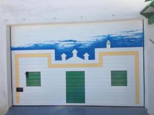 阿索马达Casa Tinasoria的白色车库门,上面有画作