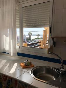 博罗尼亚Son de Mar 2的带水槽的厨房台面和窗户