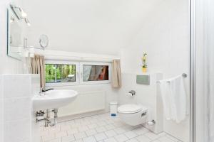 萨斯尼茨Restaurant & Hotel Baumhaus Hagen的白色的浴室设有卫生间和水槽。