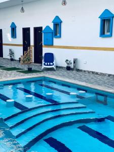 达哈布Golden Plaza Dahab Resort的大楼前的蓝色海水游泳池