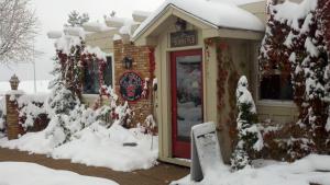 布鲁姆菲尔德Hilltop Inn Broomfield Denver的雪中装着红色门的商店