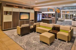 堪萨斯城堪萨斯城机场假日酒店的带沙发和平板电视的大堂。