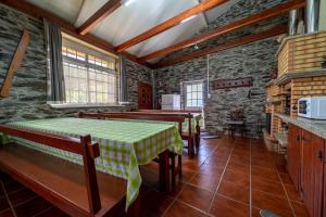 维拉·雷阿尔Casa da Passagem的一间设有两张桌子和石墙的用餐室