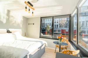 阿姆斯特丹2 Houseboat Suites Amsterdam Prinsengracht的卧室配有床、桌子和窗户。