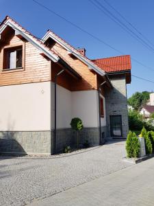 克雷尼察Pod Modrzewiami的一座有红色屋顶和车道的房子