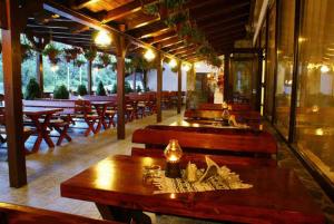 Bradu凡塔尼塔海度库酒店的餐厅设有木长椅和桌子
