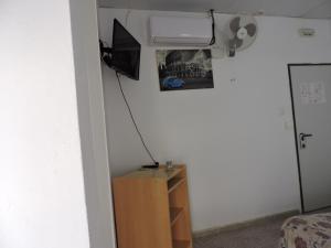阿尔赫西拉斯豪斯皮达耶阿尔赫西拉斯酒店的一间卧室配有一张床,墙上配有电视