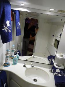 圣雷莫Sanremo charter boat and breakfast的一位妇女拍着浴室水槽的照片