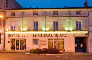 科涅克Cit'Hotel Le Cheval Blanc Cognac Centre的夜间街道拐角处的酒店