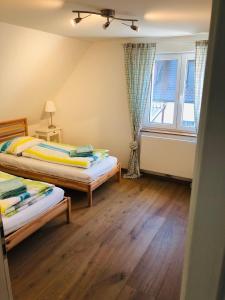 腓特烈港Ferienhaus Jehle Friedrichshafen的一间卧室设有两张床和窗户。