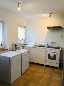 腓特烈港Ferienhaus Jehle Friedrichshafen的厨房配有白色橱柜和炉灶烤箱。
