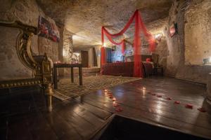Guzelyurt卡帕多奇亚厄赫拉热峡谷洞穴酒店的一间设有一张床的客房,地板上设有一张桌子和蜡烛