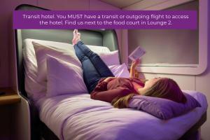 史基浦阿姆斯特丹史基浦优特艾尔过境酒店的躺在飞机上床上的妇女