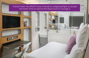 史基浦阿姆斯特丹史基浦优特艾尔过境酒店的一间医院间,配有床和电视