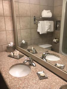 克尔维尔山丘会议中心酒店的一间带两个水槽和镜子的酒店浴室