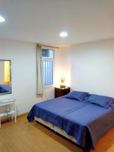 拉库布蕾B&B Garden Atelier的一间卧室设有蓝色的床和窗户。