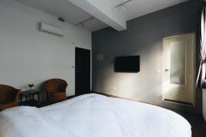 花莲市文創輕旅-近東大門夜市-車位免費可預約的卧室配有一张床,墙上配有电视