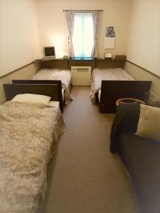 茅野四季之宿宾馆的一间设有两张床和一张沙发的房间