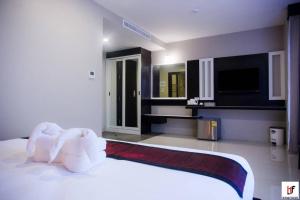 素叻The Harbour Front Hotel的卧室配有一张白色大床和电视。