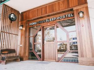 北冲More than Sleep Hostel Pak Chong-Khao yai的一座有标志的建筑,上面的读物比睡觉的旅馆多