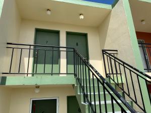 MangilaoCasa De Pedro Entire Apartment的一座带两扇绿门和楼梯的建筑