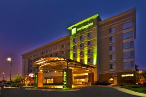 罗缪勒斯Holiday Inn Detroit Metro Airport, an IHG Hotel的上面有绿色标志的酒店大楼