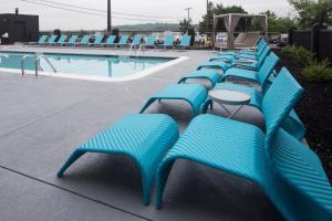 哈里斯堡Hotel Indigo Harrisburg – Hershey的游泳池旁的一排蓝色长椅