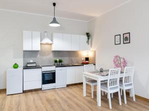 别尔斯克-比亚拉Lucky Place BASIC的厨房配有白色橱柜和桌椅