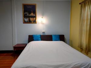 湄宏颂蚌迪楼酒店的卧室配有带蓝色枕头的大型白色床