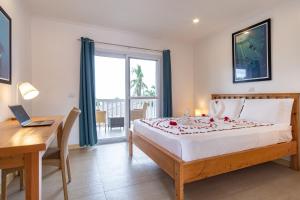莫阿尔博阿Cebu Seaview Dive Resort的一间卧室配有一张床、一张书桌和一个窗户。