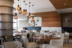 德班德班乌兰加智选假日酒店的餐厅设有木制天花板和桌椅