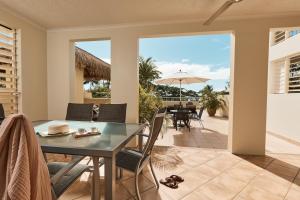 三一海滩变海海滩公寓酒店的用餐室配有桌椅和遮阳伞