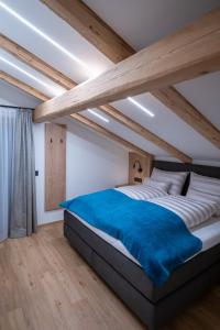 阿尔卑巴赫Apartment Haus Schönwies的一间卧室配有一张带蓝色毯子的大床