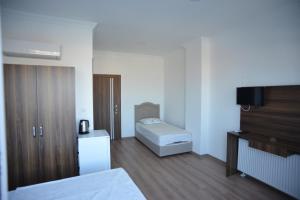 伊兹密尔Yeşilyurt Residence的一间卧室配有一张床和一台电视
