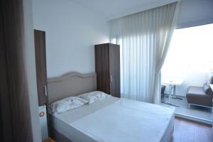 伊兹密尔Yeşilyurt Residence的一间带白色床的卧室和一间客厅