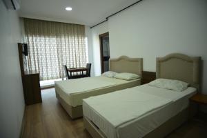伊兹密尔Yeşilyurt Residence的客房设有两张床、一把椅子和窗户。