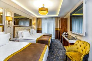 伊斯坦布尔Beethoven Senfoni Hotel的酒店客房,配有两张床和椅子